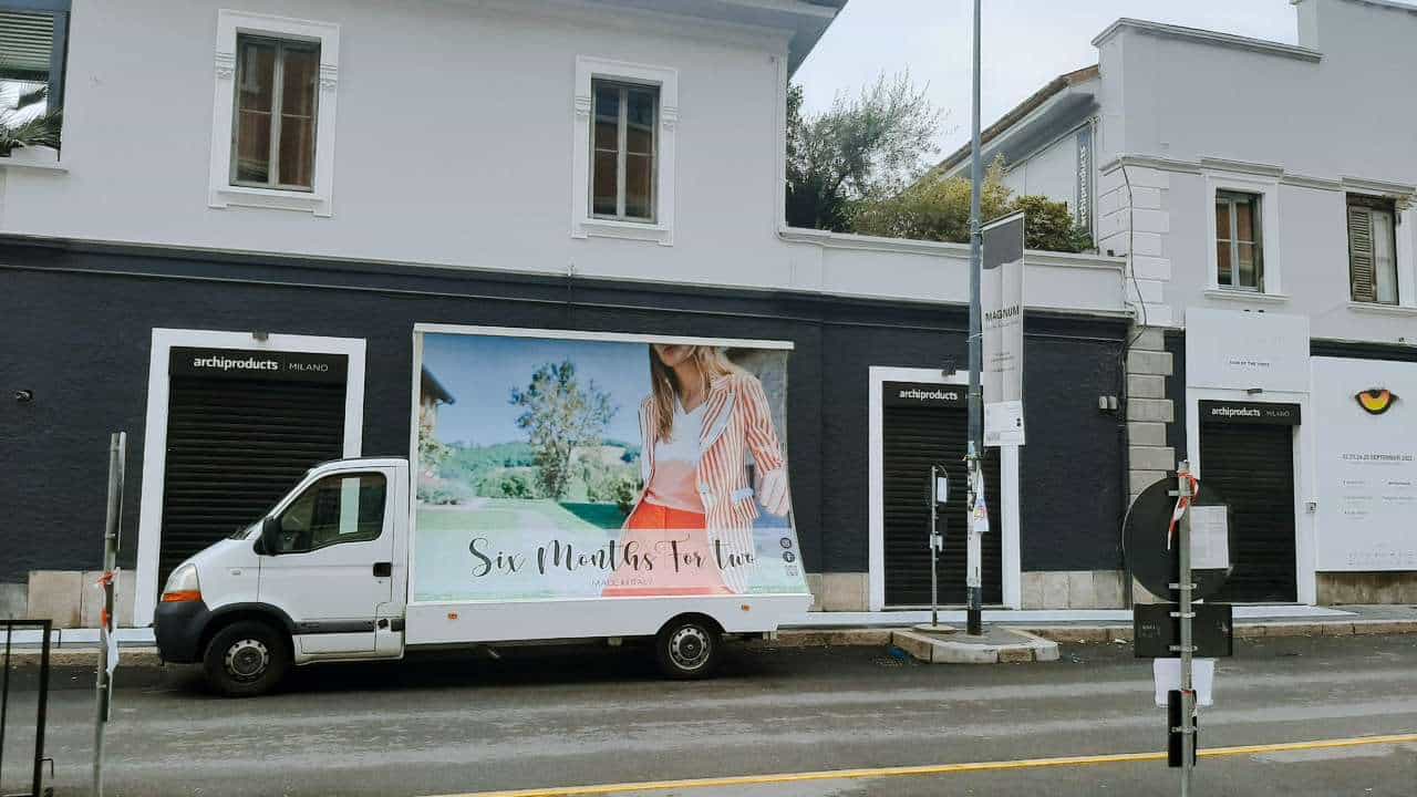 Camion vela pubblicitario con campagna moda e tema mare parcheggiato lungo una via cittadina