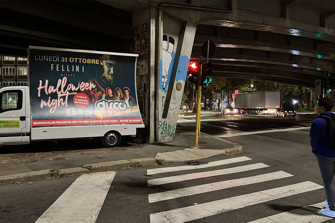 Camion vela pubblicitario di notte con campagna Halloween Night Fellini presso un incrocio