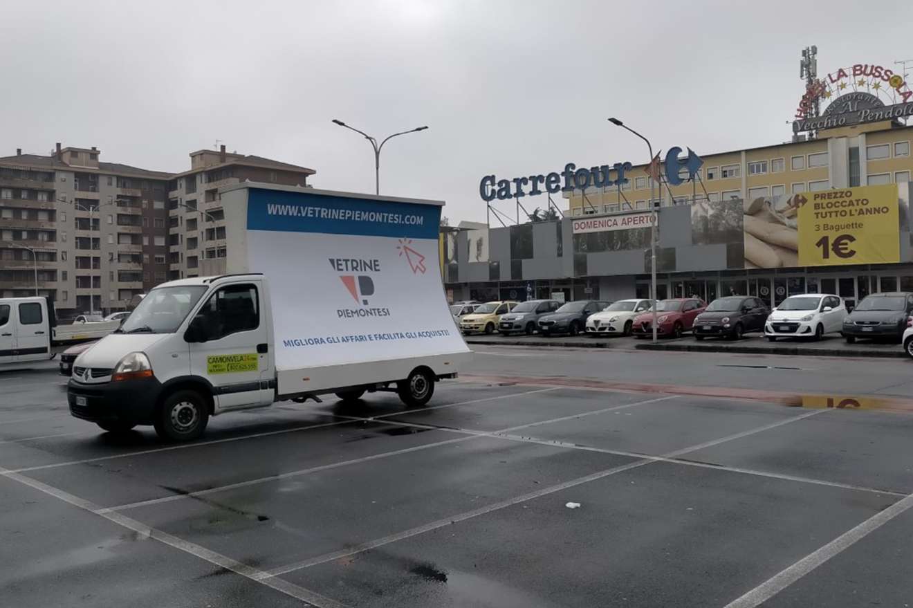 Camion vela pubblicitario nel parcheggio del Carrefour in una giornata di pioggia