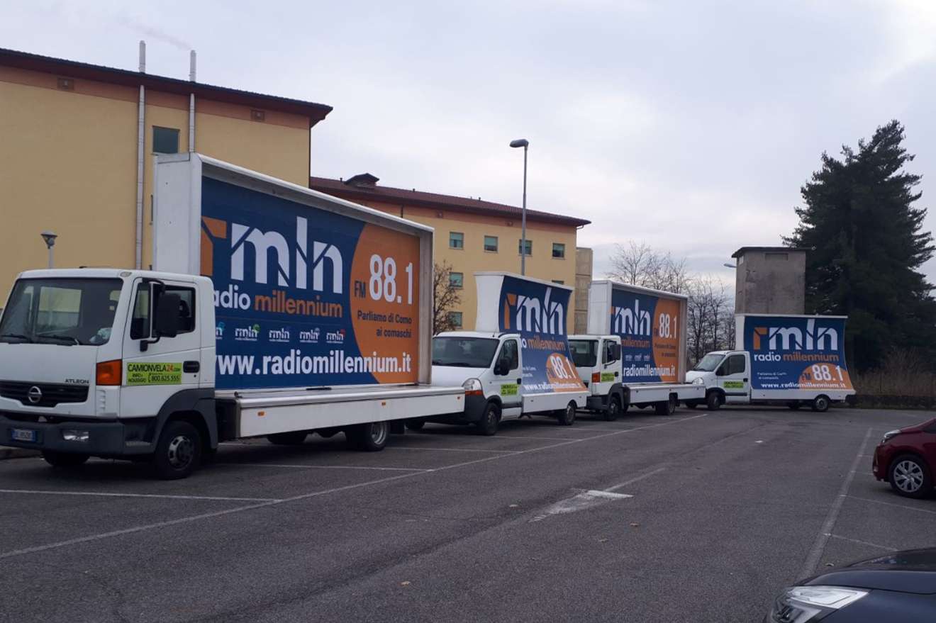 Flotta di camion vela Radio Millennium 88.1 parcheggiata in un piazzale