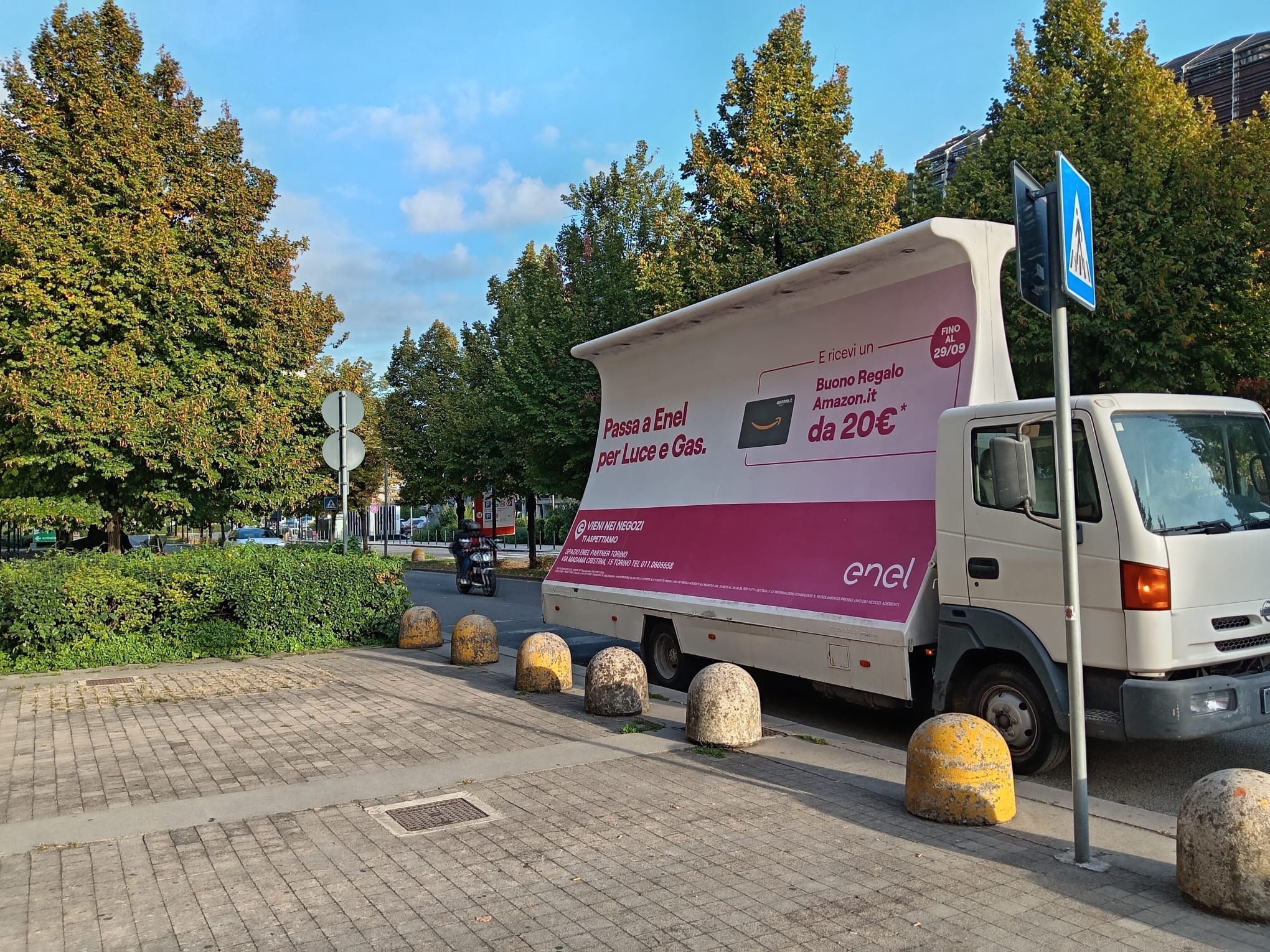 Camion vela pubblicitario 6x3 con campagna Enel in sosta su un viale alberato a Torino