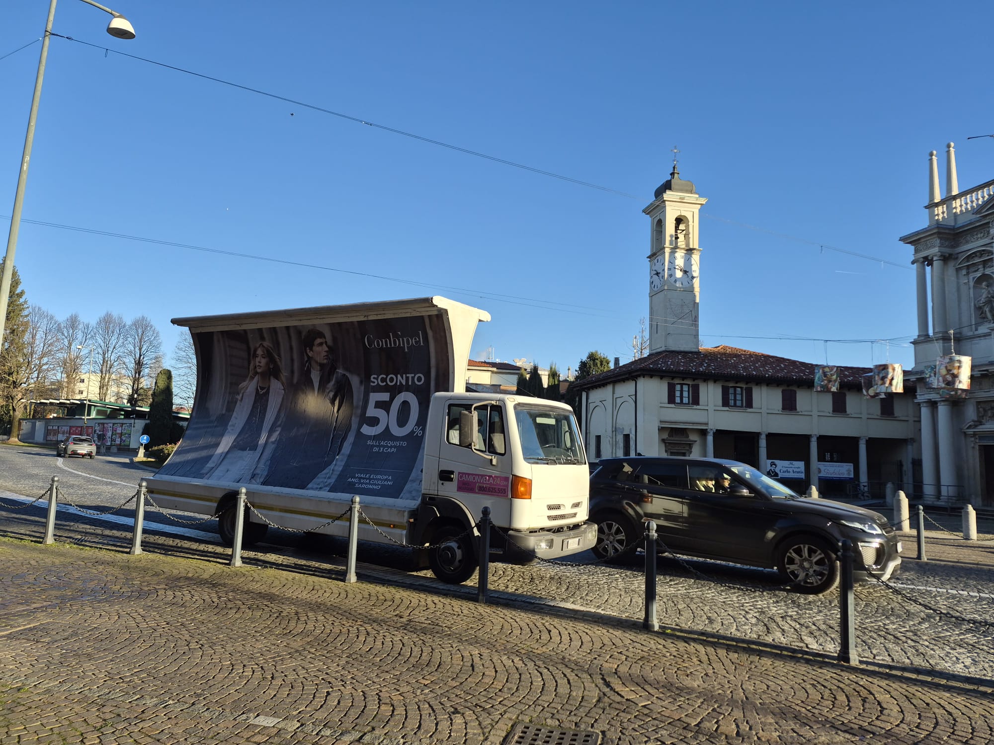 Camion vela Conbipel in transito nel centro storico di Saronno durante una campagna itinerante